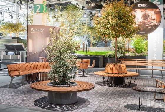 Eine geschwungene Sitzbank aus Holz mit einem Tisch und zwei Stühlen